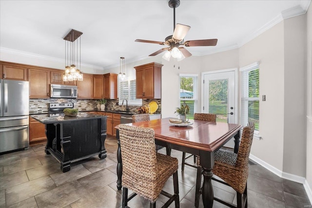 dining room featuring ornamental molding, ceiling fan, and a healthy amount of sunlight