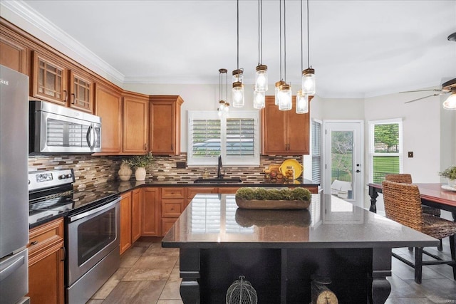 kitchen with tasteful backsplash, brown cabinetry, appliances with stainless steel finishes, and a sink