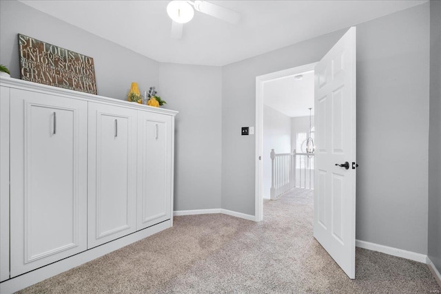 interior space with baseboards and light carpet