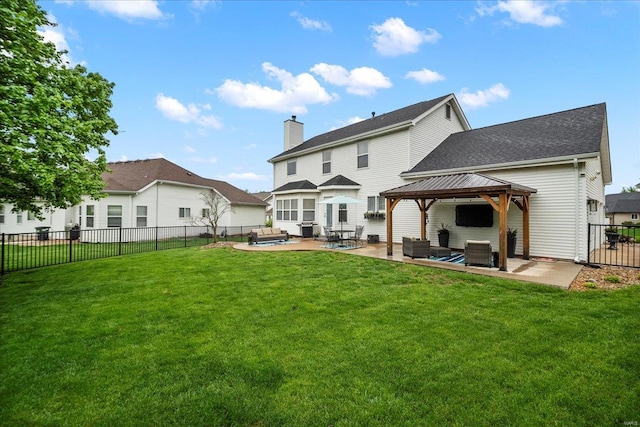 rear view of house featuring a fenced backyard, a gazebo, a shingled roof, a patio area, and a lawn