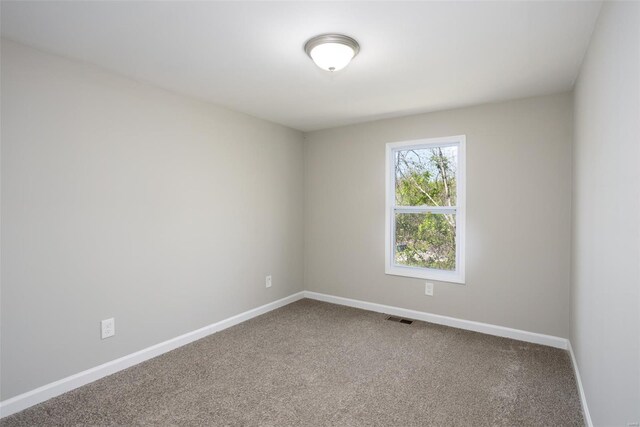 carpeted empty room featuring baseboards and visible vents