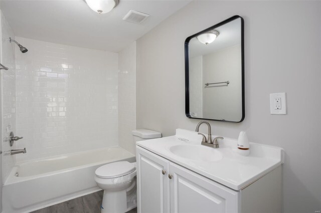 full bathroom with shower / bathing tub combination, visible vents, wood finished floors, vanity, and toilet