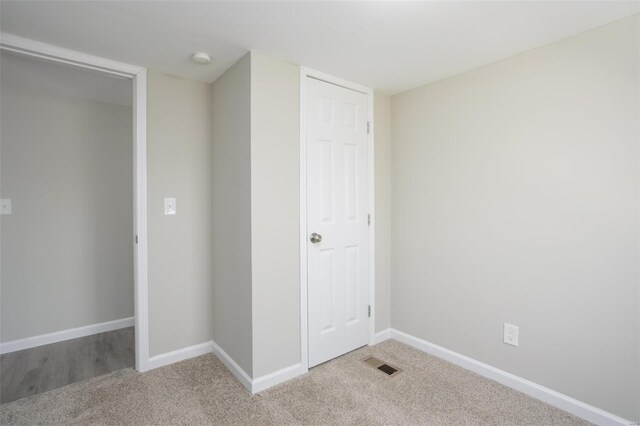 unfurnished bedroom featuring visible vents, baseboards, and light carpet