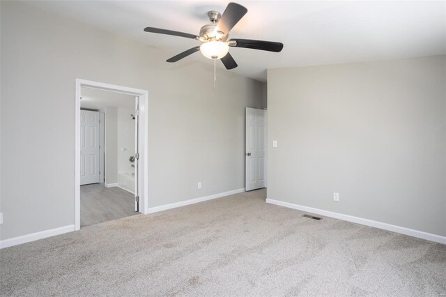 unfurnished bedroom featuring connected bathroom, ceiling fan, carpet floors, baseboards, and visible vents