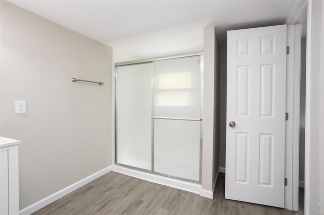 unfurnished bedroom with a closet, baseboards, and wood finished floors