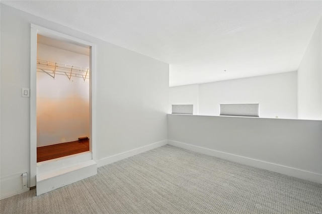 spare room featuring carpet floors and baseboards