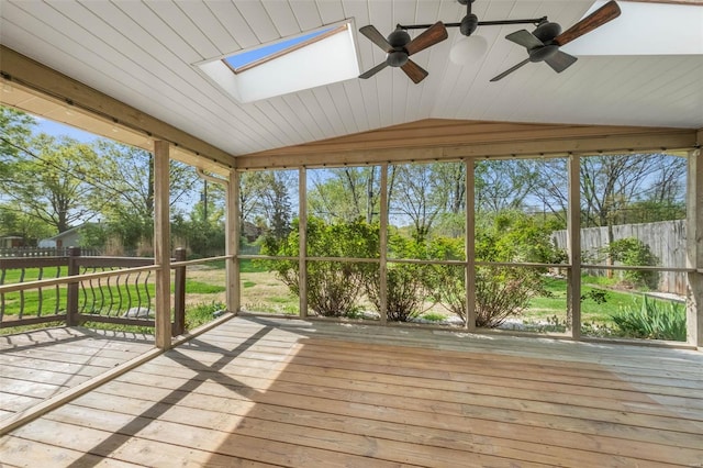 unfurnished sunroom with a deck, lofted ceiling with skylight, and ceiling fan