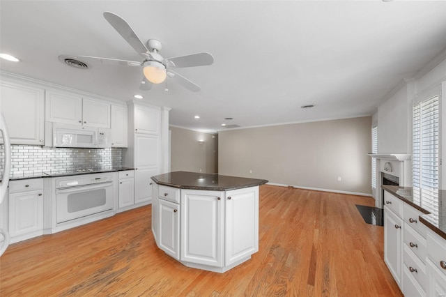 kitchen featuring tasteful backsplash, ceiling fan, white appliances, and white cabinetry