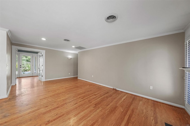 empty room featuring baseboards, visible vents, and ornamental molding