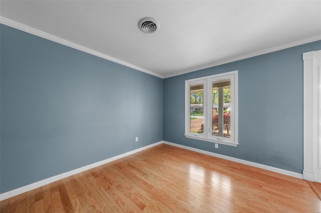 unfurnished room featuring visible vents, light wood-type flooring, crown molding, and baseboards