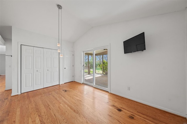 unfurnished bedroom featuring vaulted ceiling, light wood finished floors, access to exterior, and baseboards