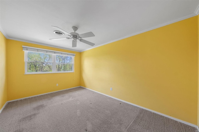 carpeted empty room with ornamental molding, a ceiling fan, visible vents, and baseboards