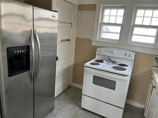 kitchen featuring stainless steel refrigerator with ice dispenser, baseboards, and electric stove