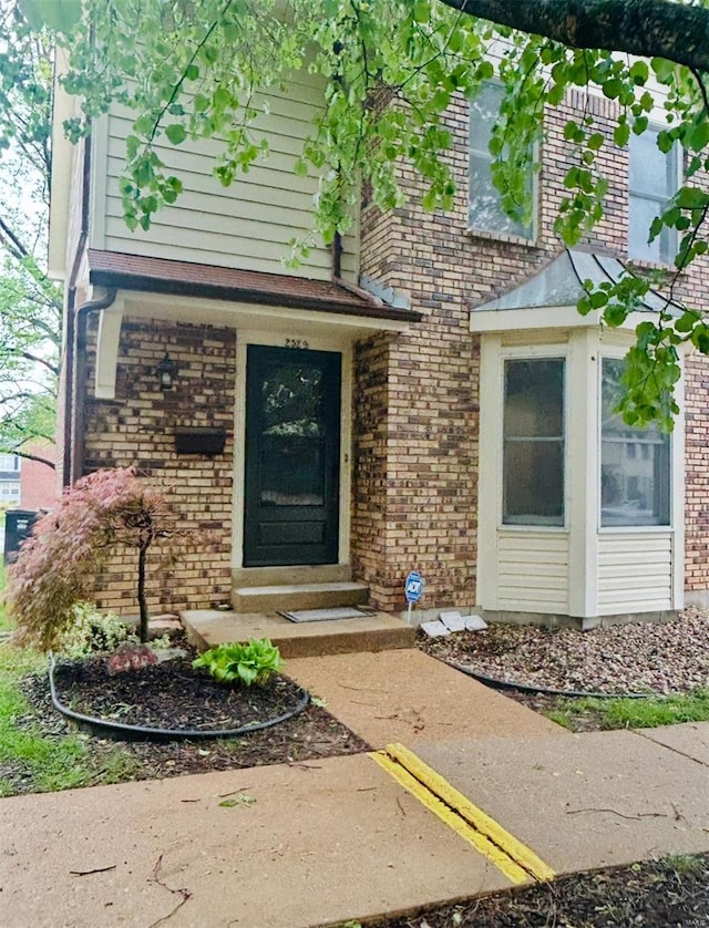 property entrance featuring brick siding