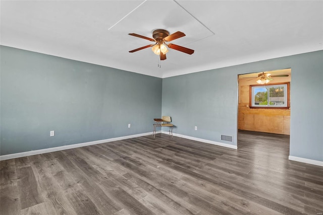spare room featuring wood finished floors, visible vents, a ceiling fan, and baseboards