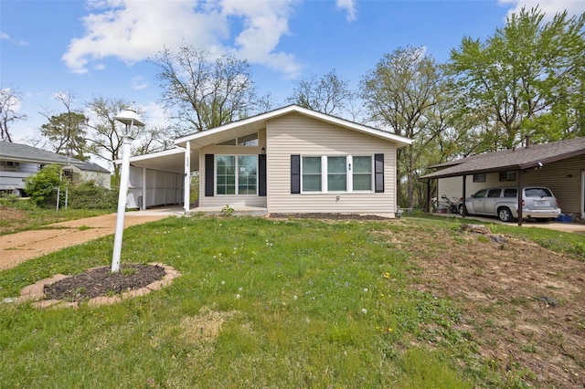 view of front of home featuring concrete driveway, an attached carport, and a front yard