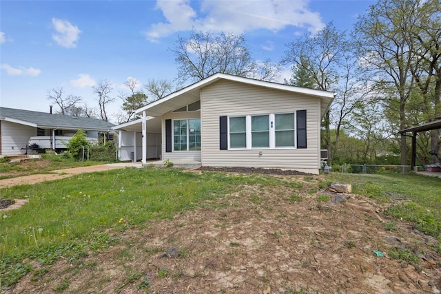 view of front facade featuring a carport, driveway, and a front yard
