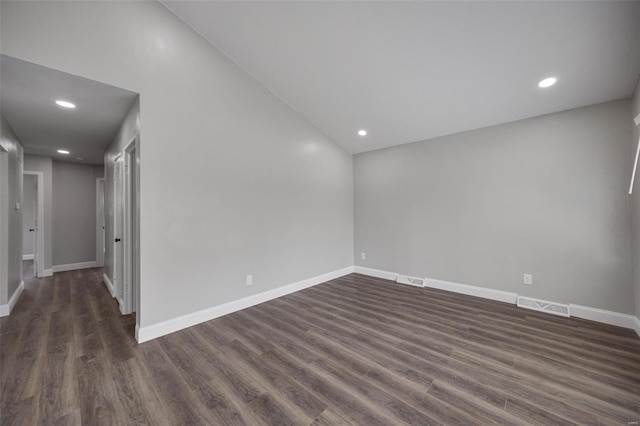 empty room with dark wood finished floors, baseboards, visible vents, and recessed lighting