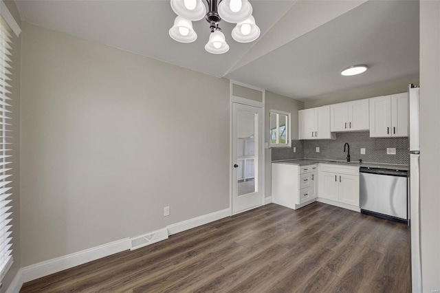 kitchen with dishwasher, freestanding refrigerator, an inviting chandelier, and dark wood finished floors