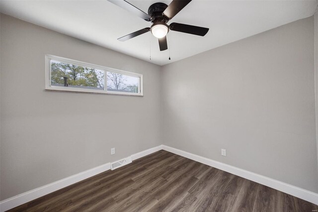 spare room featuring visible vents, baseboards, ceiling fan, and dark wood-style floors