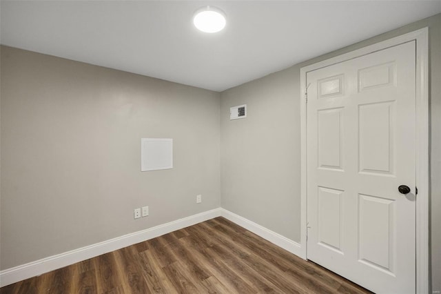 spare room with visible vents, baseboards, and dark wood-style floors