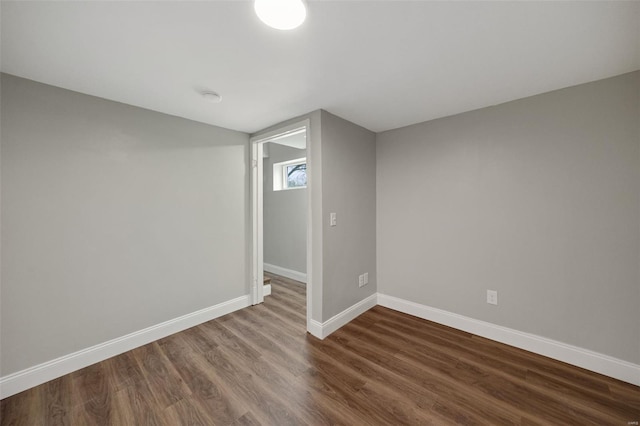 below grade area featuring dark wood finished floors and baseboards