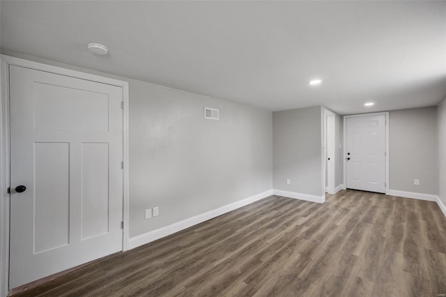 unfurnished room featuring dark wood-type flooring, visible vents, baseboards, and recessed lighting