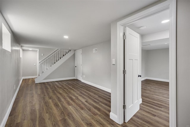 finished below grade area with baseboards, wood finished floors, recessed lighting, and stairs