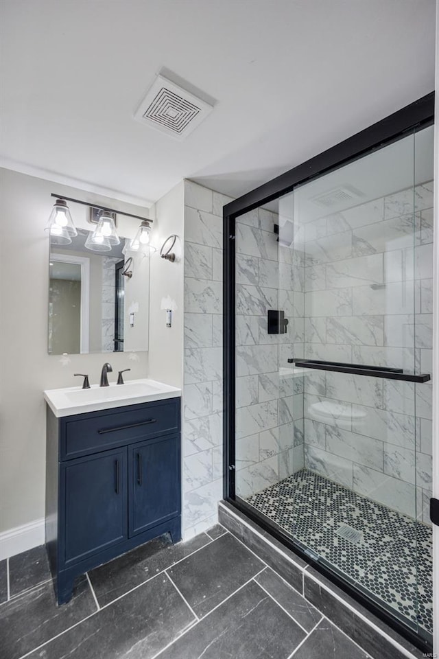 bathroom with baseboards, vanity, visible vents, and a stall shower