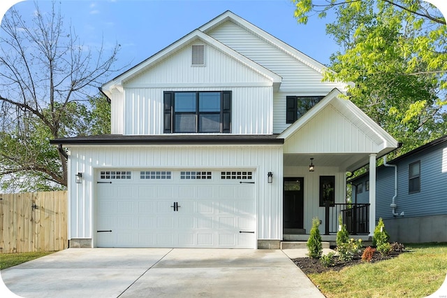 modern farmhouse with covered porch, fence, driveway, and a garage