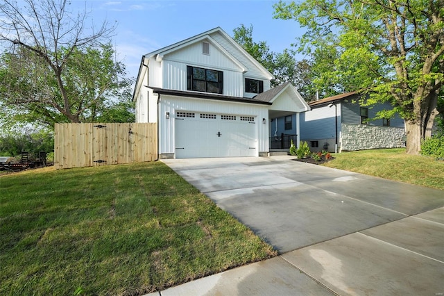 view of front facade with fence, an attached garage, a front lawn, board and batten siding, and driveway