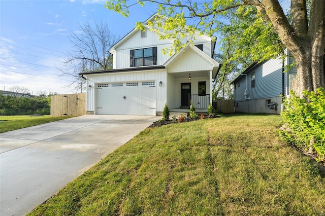 view of front of home with covered porch, driveway, a front yard, a garage, and fence