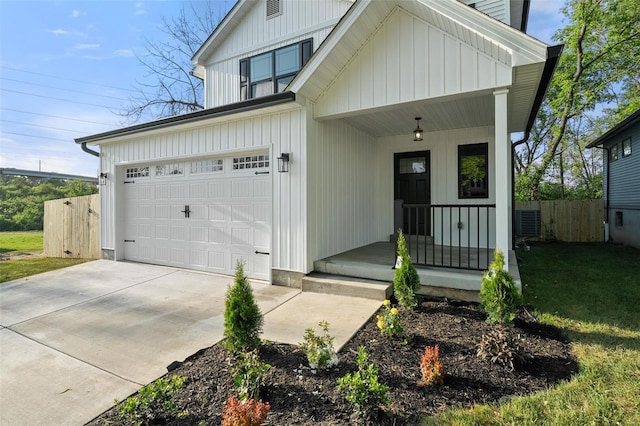 modern farmhouse featuring a porch, board and batten siding, fence, and a front yard