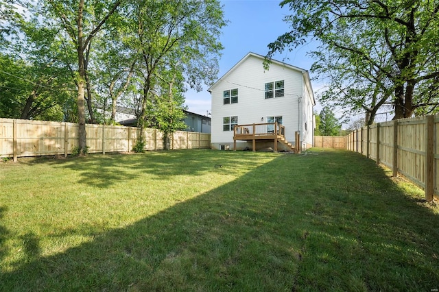 rear view of property featuring a fenced backyard, a wooden deck, a yard, and stairway