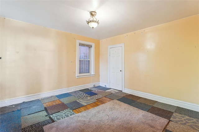 empty room with baseboards and wood finished floors