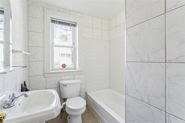 full bathroom with tile patterned floors, tile walls, toilet, and a sink