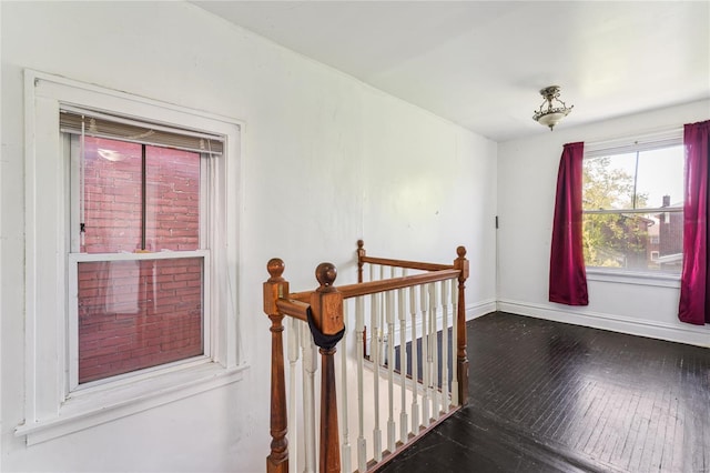 interior space featuring baseboards, wood finished floors, and an upstairs landing