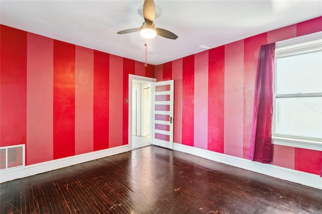 empty room featuring baseboards, visible vents, a ceiling fan, and wallpapered walls