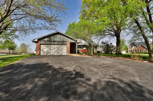 view of front of property with brick siding, aphalt driveway, and a garage