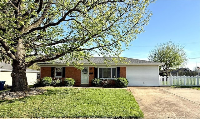 ranch-style house featuring brick siding, a front lawn, fence, and concrete driveway