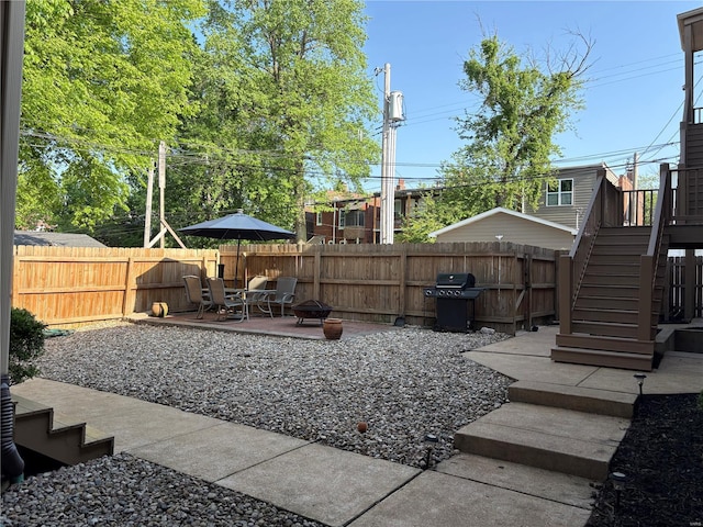 view of yard featuring a fenced backyard, stairs, a fire pit, and a patio area