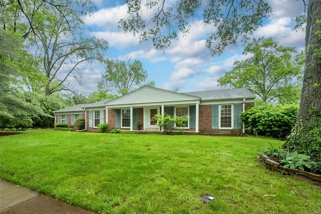 view of front of property featuring a porch, brick siding, and a front yard