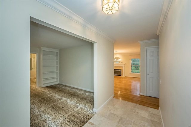 hallway featuring baseboards, an inviting chandelier, and ornamental molding