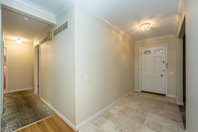 foyer entrance with crown molding, baseboards, and visible vents