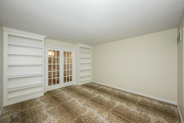 unfurnished room featuring carpet flooring, built in shelves, french doors, baseboards, and visible vents