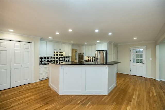kitchen with stainless steel refrigerator with ice dispenser, white cabinetry, crown molding, and light wood-type flooring
