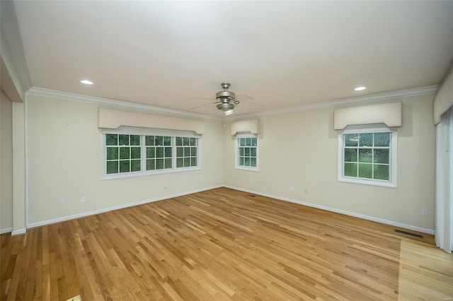 empty room featuring visible vents, ornamental molding, baseboards, and ceiling fan