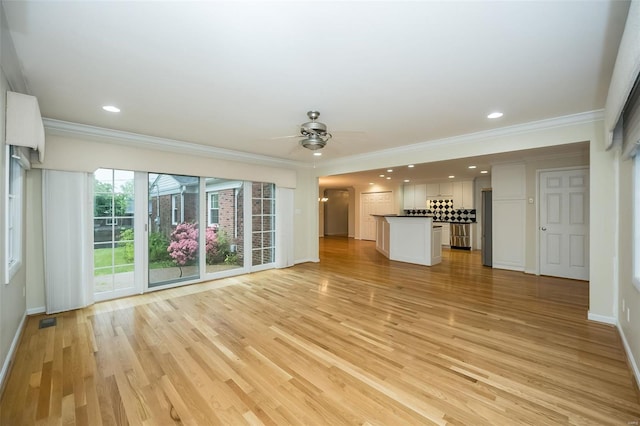 unfurnished living room with crown molding, a ceiling fan, and visible vents