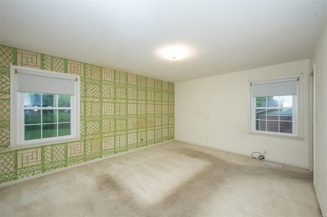unfurnished room featuring carpet and wallpapered walls