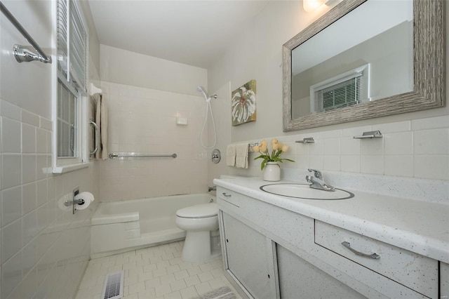 full bathroom with vanity, toilet, shower / bath combination, tile walls, and visible vents